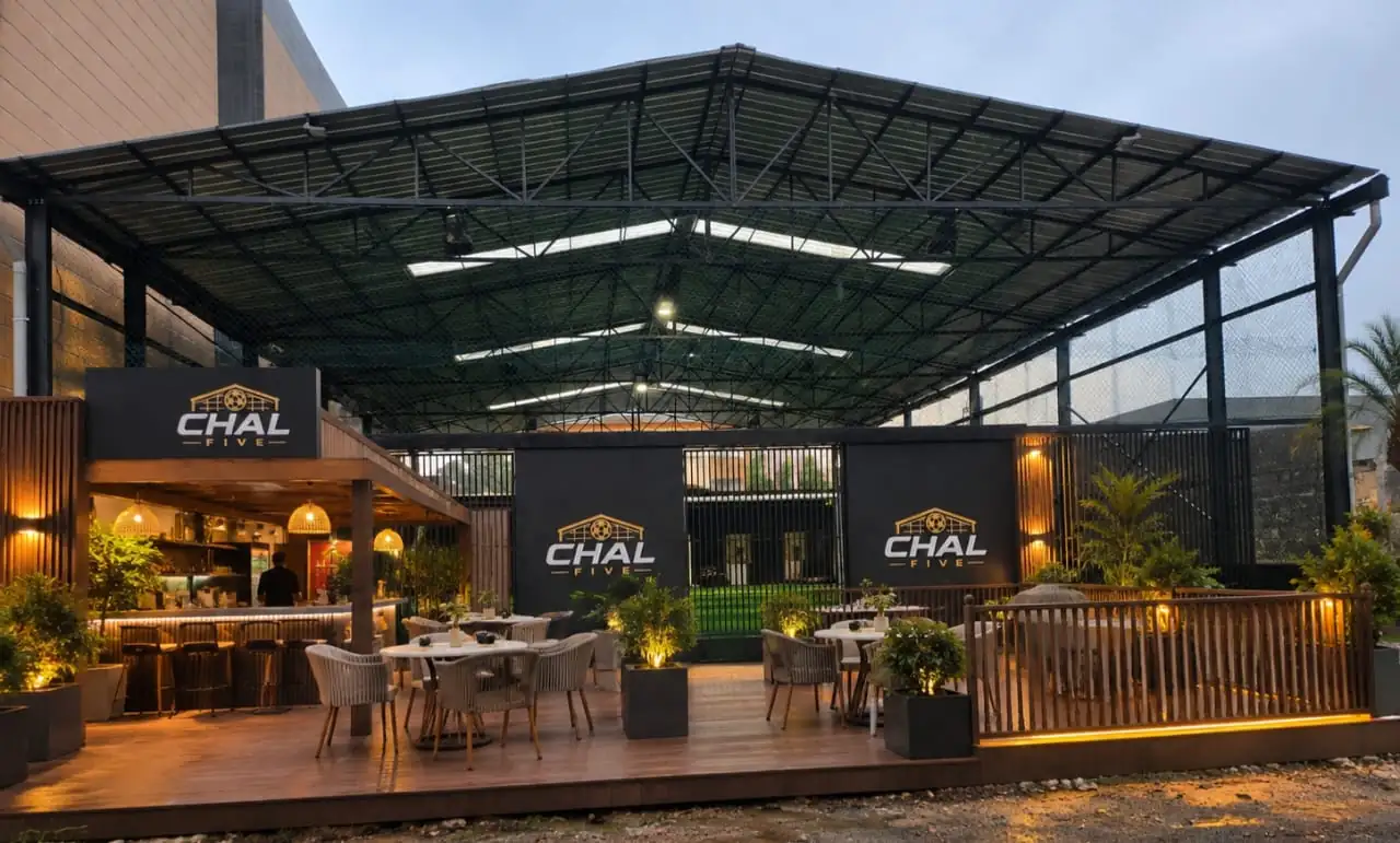 La terrasse et le bar de CHAL Five en début de soirée, devant le terrain couvert.